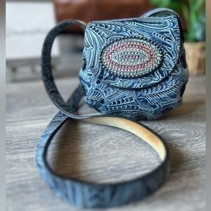 Hand tooled floral embossed blue leather shoulder mini bag w bejeweled buckle.